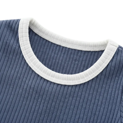 Kidsely boutique quality: Close-up of the crew neckline on the Dusty Indigo romper featuring clean stitching and Oatmeal Milk contrast trim.