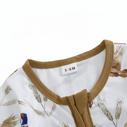 Close-up of the baby romper neckline showing the protective fabric zipper guard and ribbed brown collar.