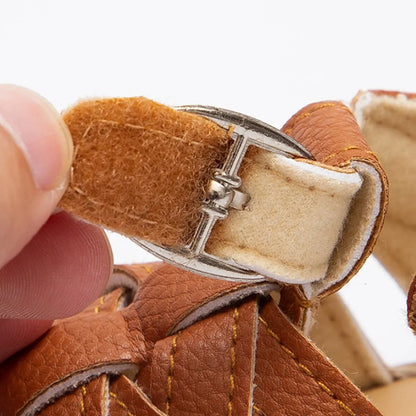 Close-up showing a hand pulling open the hidden hook-and-loop velcro strap underneath the faux metal buckle.