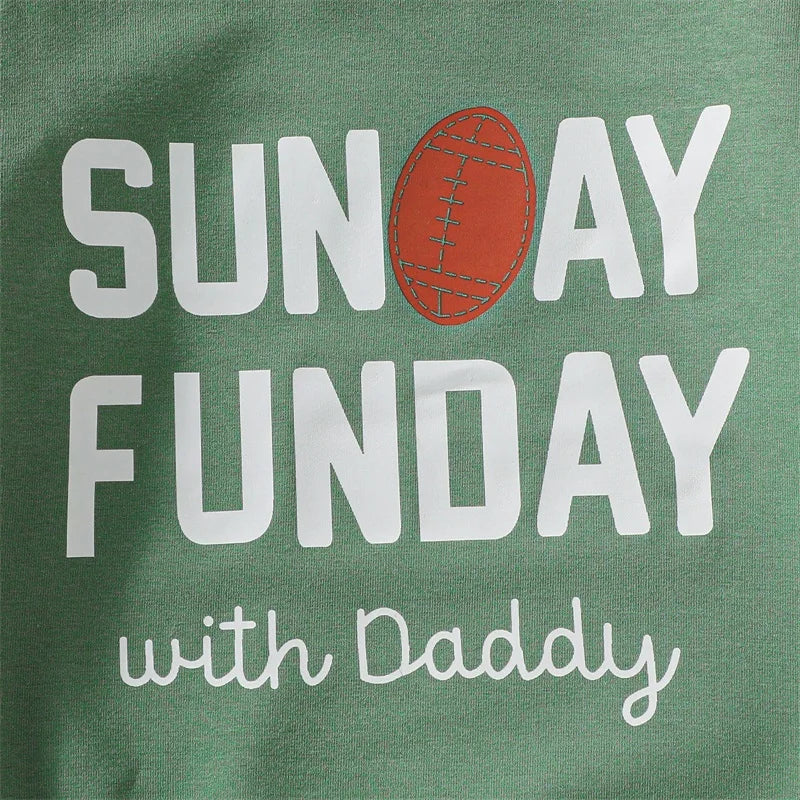 Close-up detail of the screen-printed white typography design and classic brown football illustration on the front of the infant jumpsuit.