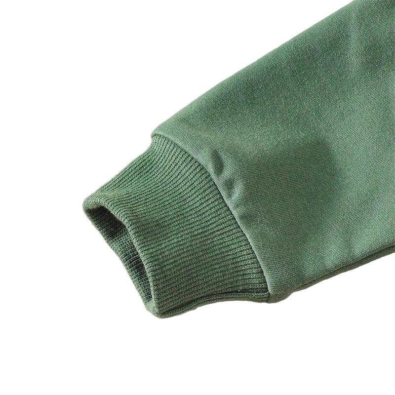 Close-up of the elasticized ribbed knit wrist cuff on the long sleeve of the baby cotton jumpsuit.