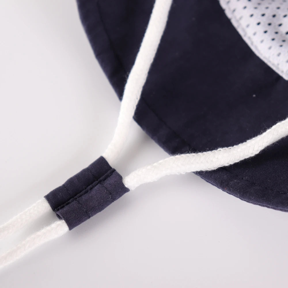 Close up of the adjustable chin strap toggle on the dark blue baby sun hat.
