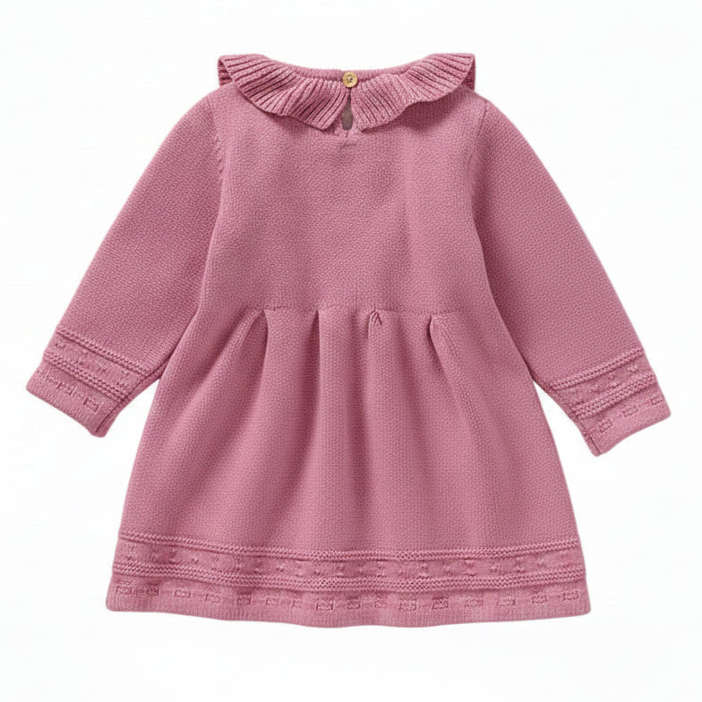 Back view of a pink long sleeve cable knit sweater dress for toddlers showing the neck button and waist pleats.
