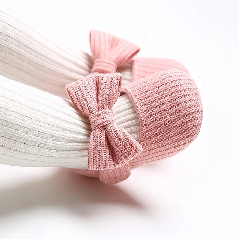 Baby wearing pink ribbed knit soft sole Mary Jane crib shoes with white ribbed tights.