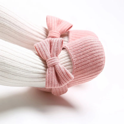 Baby wearing pink ribbed knit soft sole Mary Jane crib shoes with white ribbed tights.