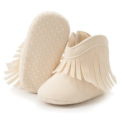 Cream baby western fringe moccasin booties showing the flexible anti-slip dotted sole on a white background.