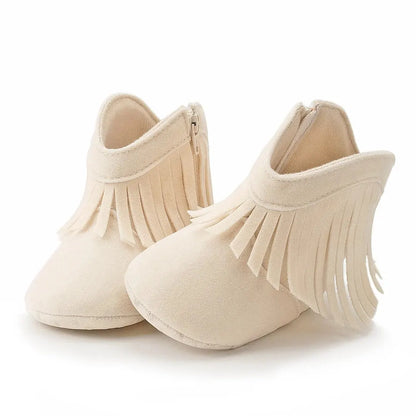 Pair of cream off-white infant fringe suede moccasin booties on a white background.