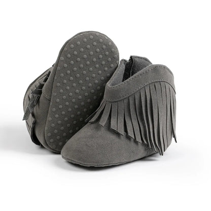 Gray baby western fringe moccasin booties showing the flexible soft sole and anti-slip dots on a white background.