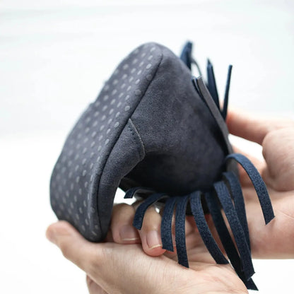 Hands flexing a navy blue soft sole baby fringe moccasin bootie to demonstrate sole flexibility and grip.