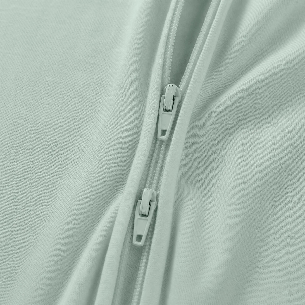 Close-up detail of smooth 2-way dual zipper on Kidsely solid sage green bamboo viscose baby sleeper