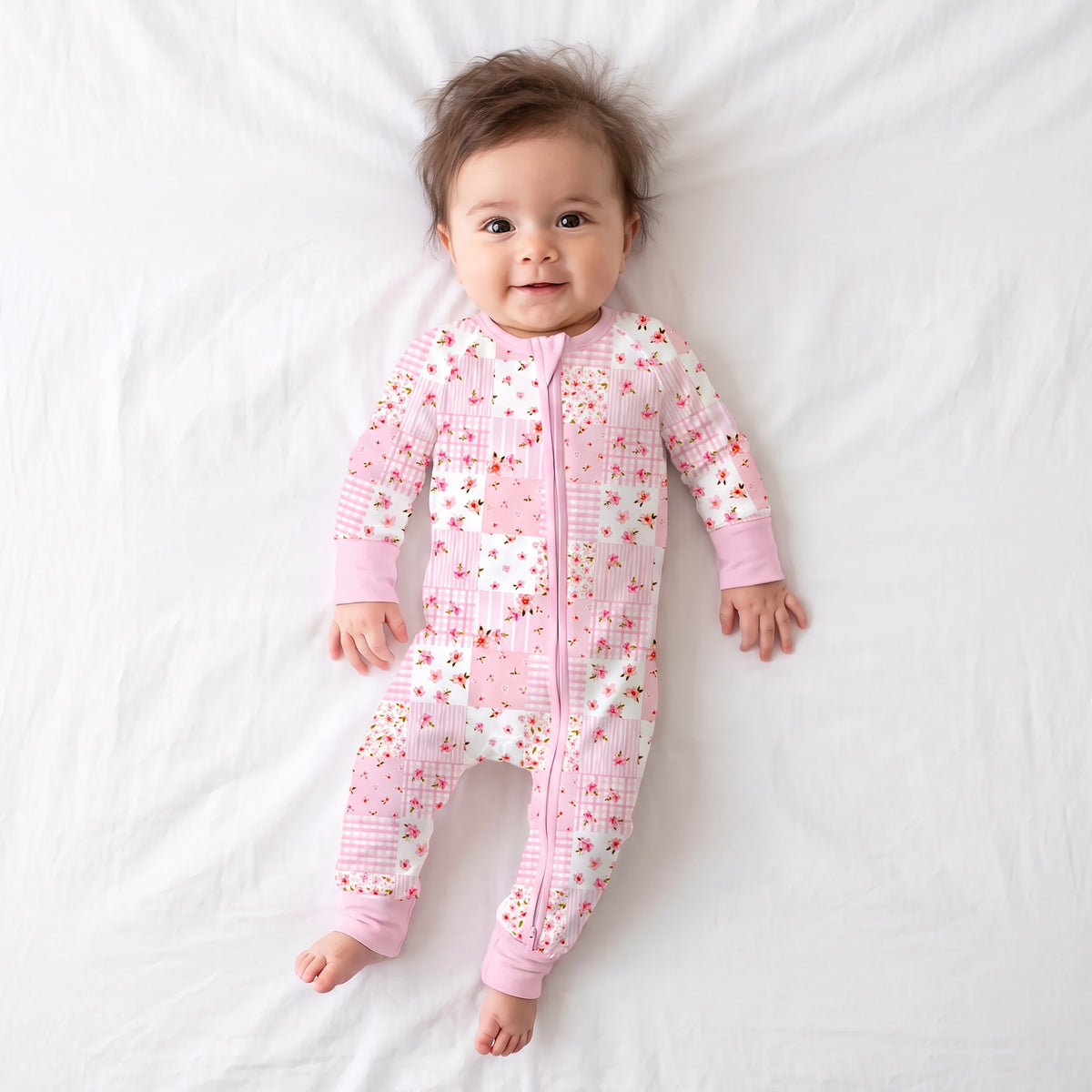 Baby girl model wearing Kidsely pink floral quilt print bamboo viscose zipper romper sleeper