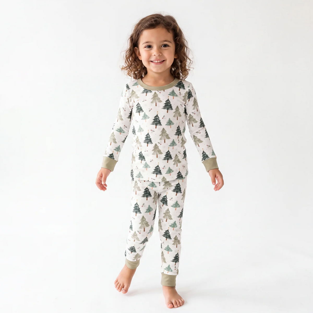 Toddler girl model standing wearing Kidsely Evergreen Christmas Trees bamboo viscose two-piece pajama set