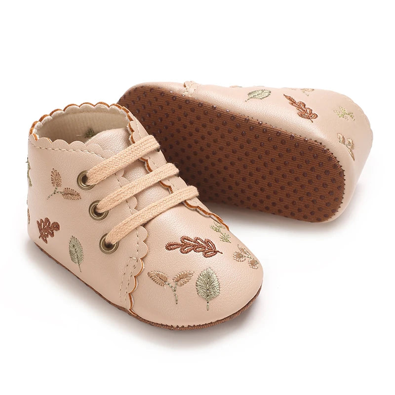 Soft anti-slip sole on beige embroidered baby girl booties.