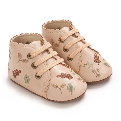 Pair of beige boho embroidered baby girl booties with scalloped edges.