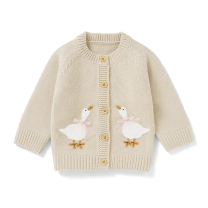 Beige baby and toddler girls knit cardigan sweater featuring two embroidered geese, flat lay on a white background.