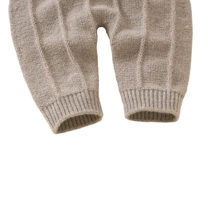 Close-up of the ribbed ankle cuffs on the beige seamless knit baby overalls.