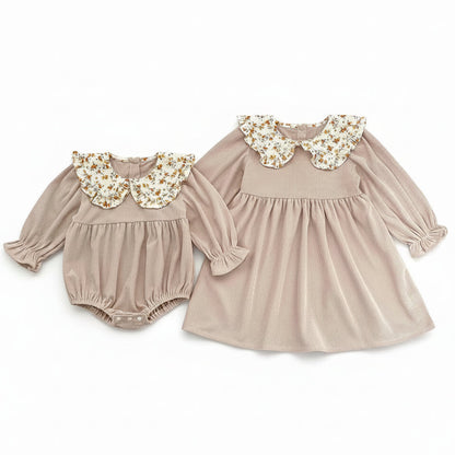 Front view of a matching beige corduroy baby romper and toddler dress set with floral Peter Pan collars.
