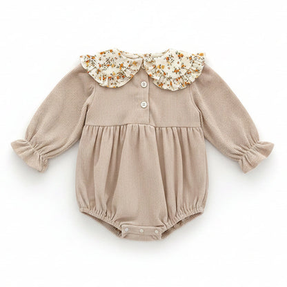 Back view of the beige ribbed corduroy baby romper showing the button closures at the back of the neck.