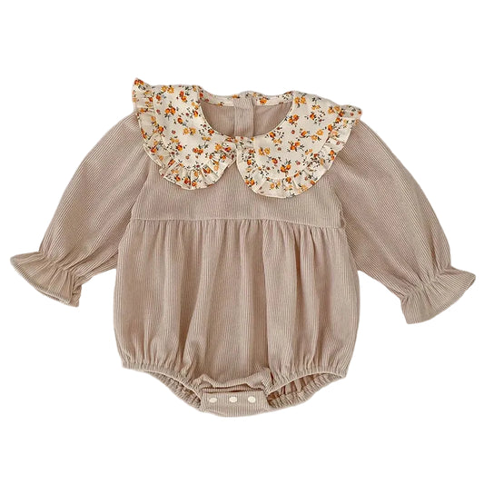 Front view of a beige ribbed corduroy baby girl long-sleeve romper featuring a ruffled floral Peter Pan collar.