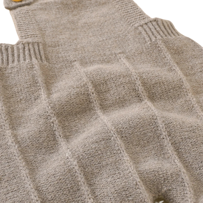 Close-up showing the soft, ribbed knit texture on the main body of the beige baby overalls.
