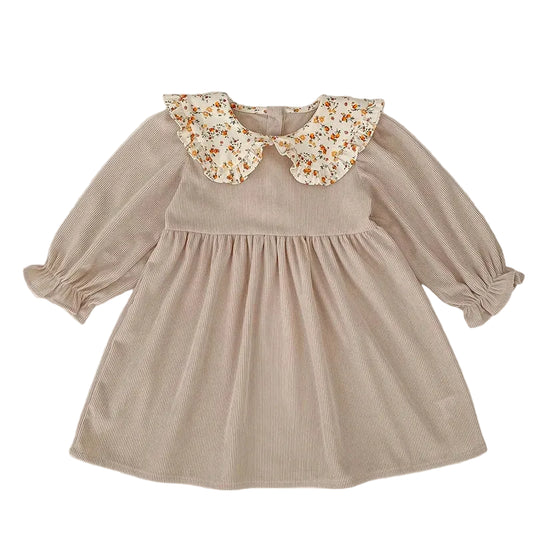 Front view of a beige ribbed corduroy long-sleeve toddler dress with a floral ruffled Peter Pan collar.