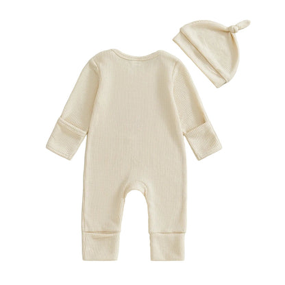 Back view of the beige long-sleeve waffle knit baby jumpsuit and matching knot hat on a white background.