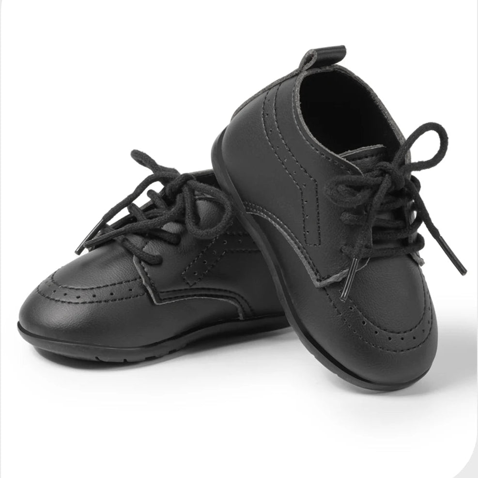 Pair of classic black smooth faux leather infant dress shoes by Kidsely, perfect for ring bearers and formal tuxedo outfits.