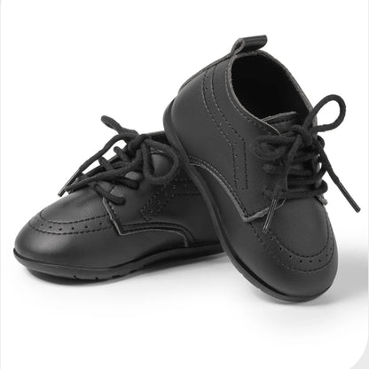 Pair of classic black smooth faux leather infant dress shoes by Kidsely, perfect for ring bearers and formal tuxedo outfits.