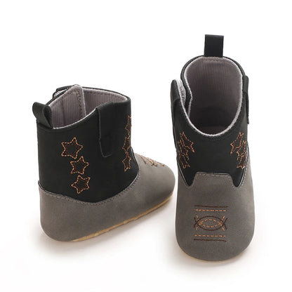 Two black and grey infant cowboy boots, one facing forward and one showing the back pull-tab for easy dressing.