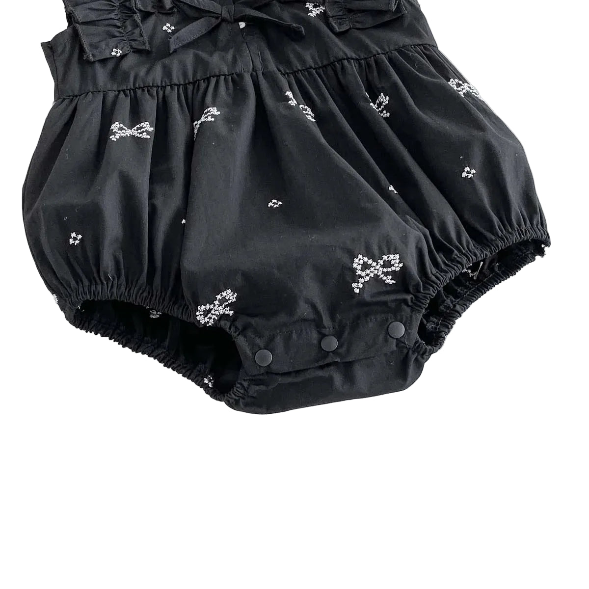Close up of the gathered elastic leg openings and bottom silhouette on a black baby girl bubble romper.
