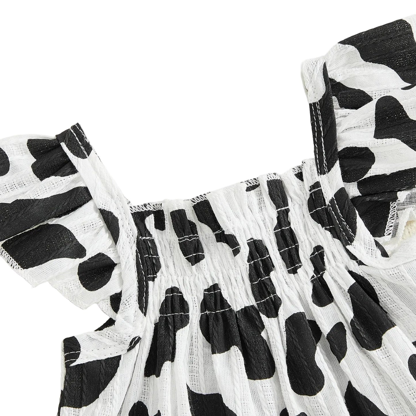 Close-up detail of the black and white cow print smocked top with ruffled flying sleeves.
