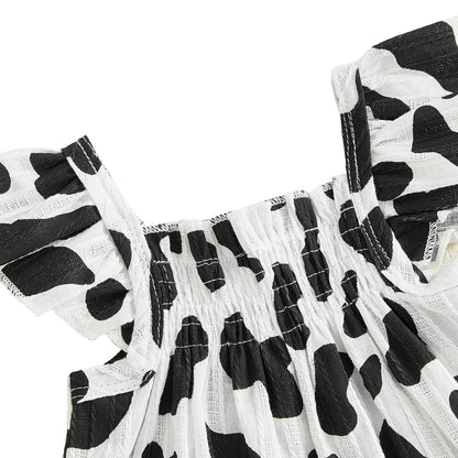 Close-up detail of the black and white cow print smocked top with ruffled flying sleeves.