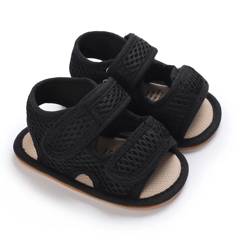 Black first walker mesh sandals for baby boys with adjustable straps and breathable honeycomb fabric.