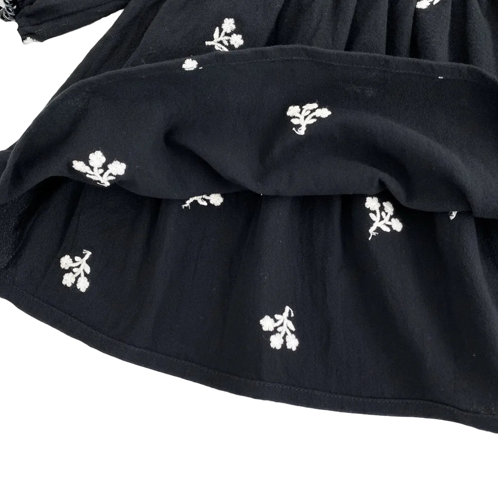 Close-up of the bottom hem and interior fabric of the black cotton blend toddler dress.