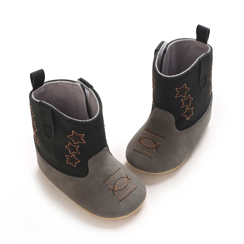 High angle view of black and grey faux-suede baby cowboy boots showing the wide opening and side closure.