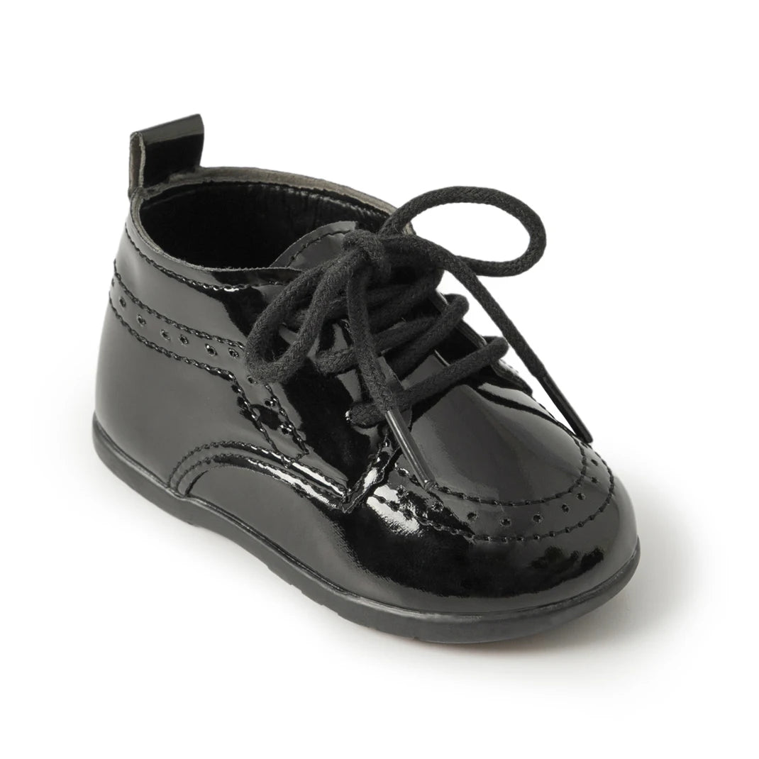 Main studio shot of a Kidsely single black high-gloss patent faux leather baby brogue oxford shoe with black laces on a clean white background.