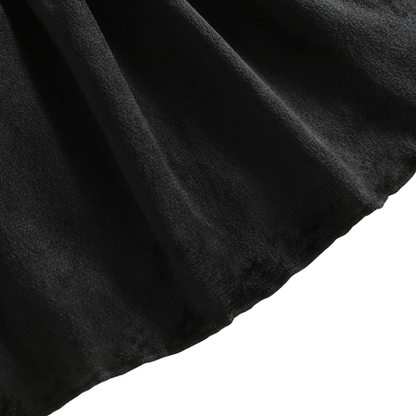 Close-up showing the soft, textured black fabric and draped hem of the girls Halloween dress.