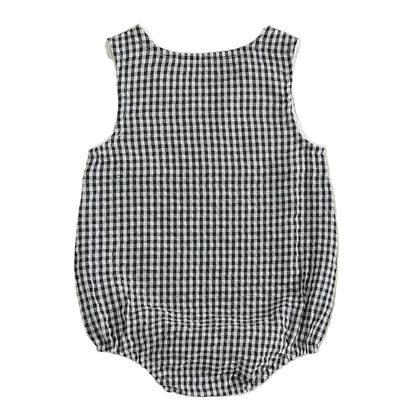 Full back view of the unisex black and white checkered seersucker baby bubble romper, highlighting the gathered elastic leg openings and relaxed bubble silhouette.