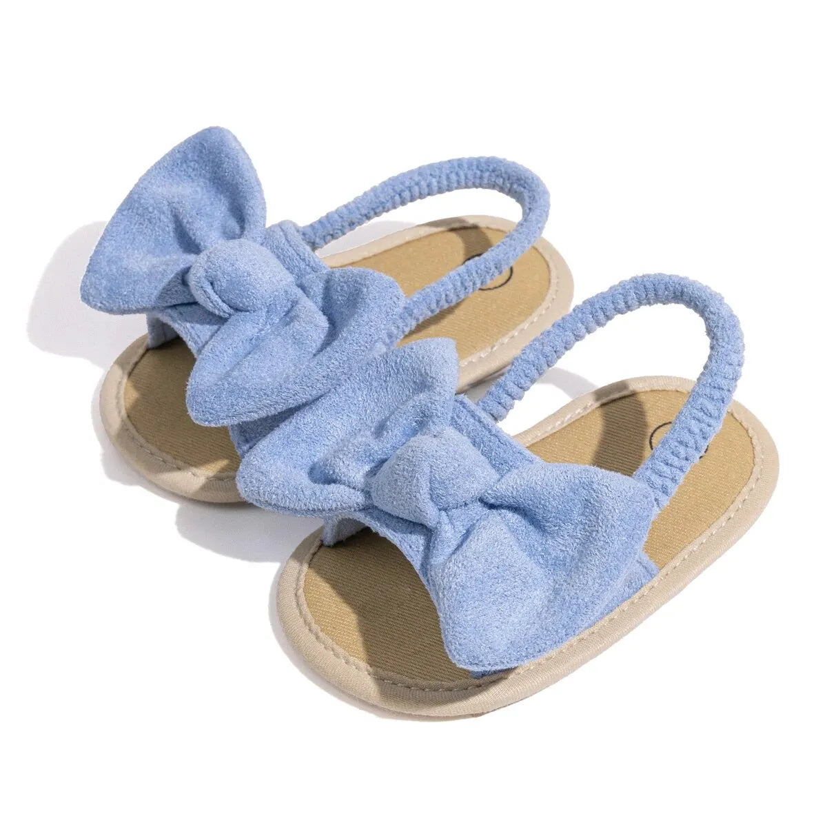 Pair of light blue baby girl soft sole sandals with an oversized brushed fabric bow and elastic strap.