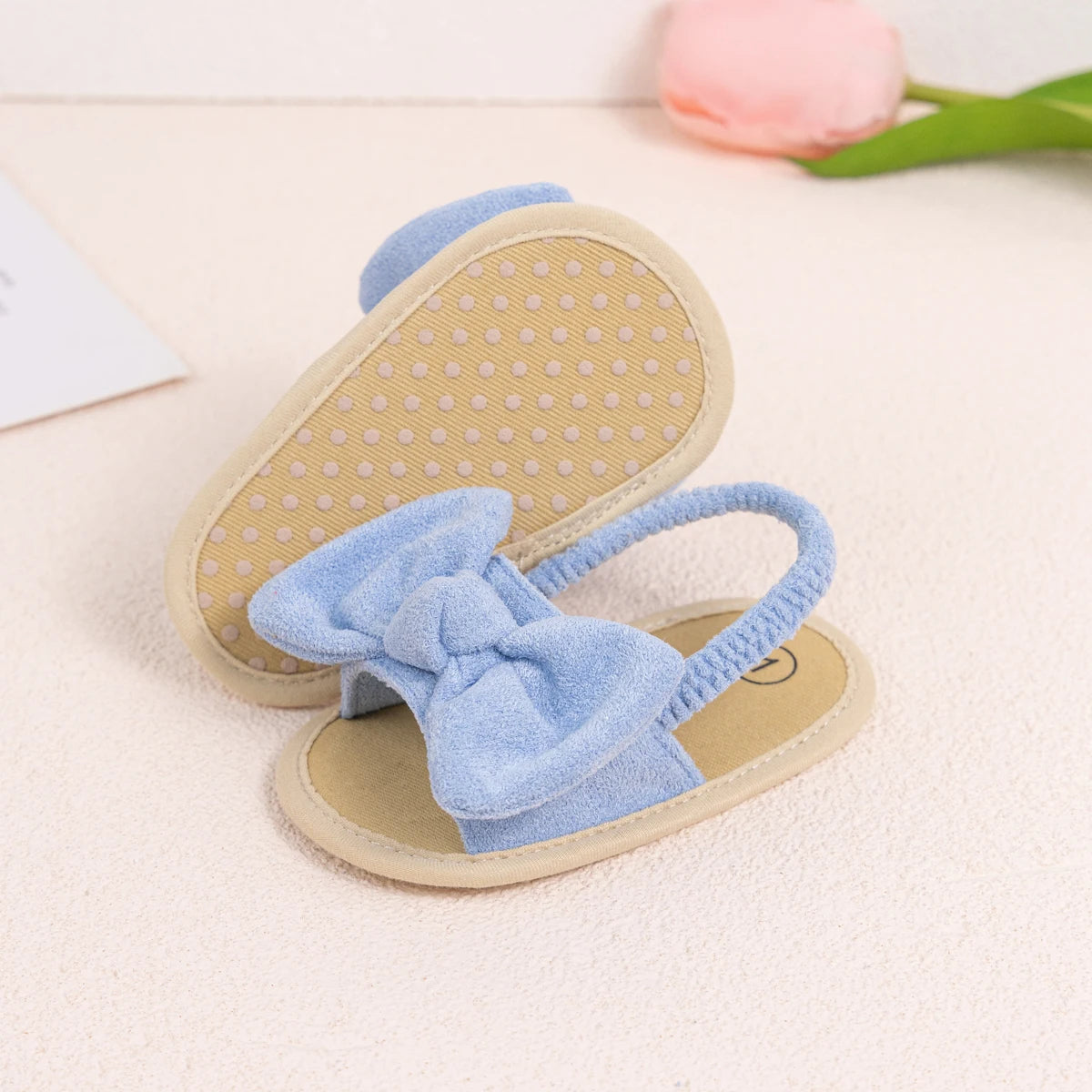 Anti-slip dotted sole on the bottom of a light blue baby soft sole sandal.