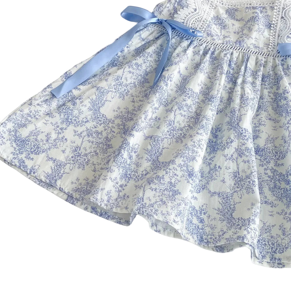Detail shot of the monochrome blue floral toile de jouy pattern on the dress fabric.