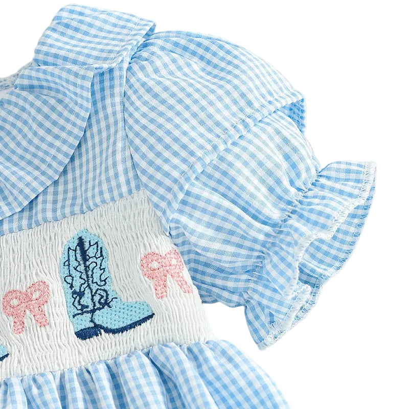 Detail shot showing the short puff sleeve and western cowgirl embroidery on the blue gingham baby romper.