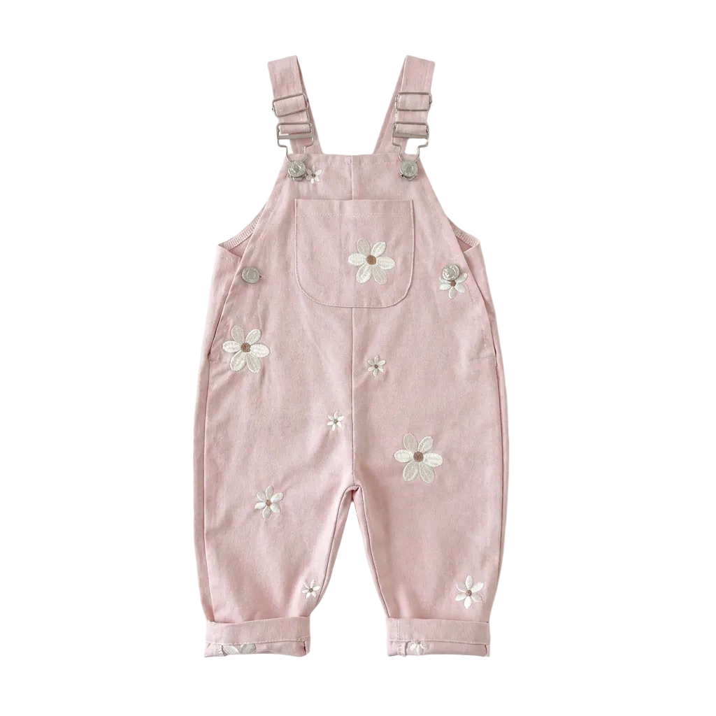 Blush pink Kidsely toddler overalls featuring embroidered white daisies and a front chest pocket, displayed flat against a white background.