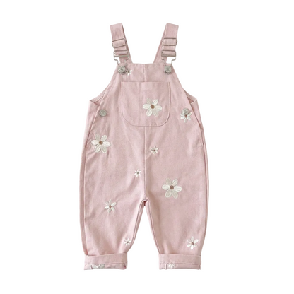 Blush pink Kidsely toddler overalls featuring embroidered white daisies and a front chest pocket, displayed flat against a white background.