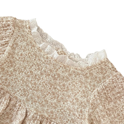  Close-up detail of the baby girl's boho floral romper neckline, showcasing the delicate white scalloped lace edge.