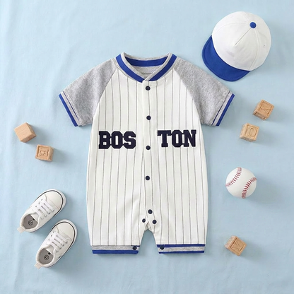 Baby romper with 'Boston' print, baseball cap, shoes, and blocks on a light blue background