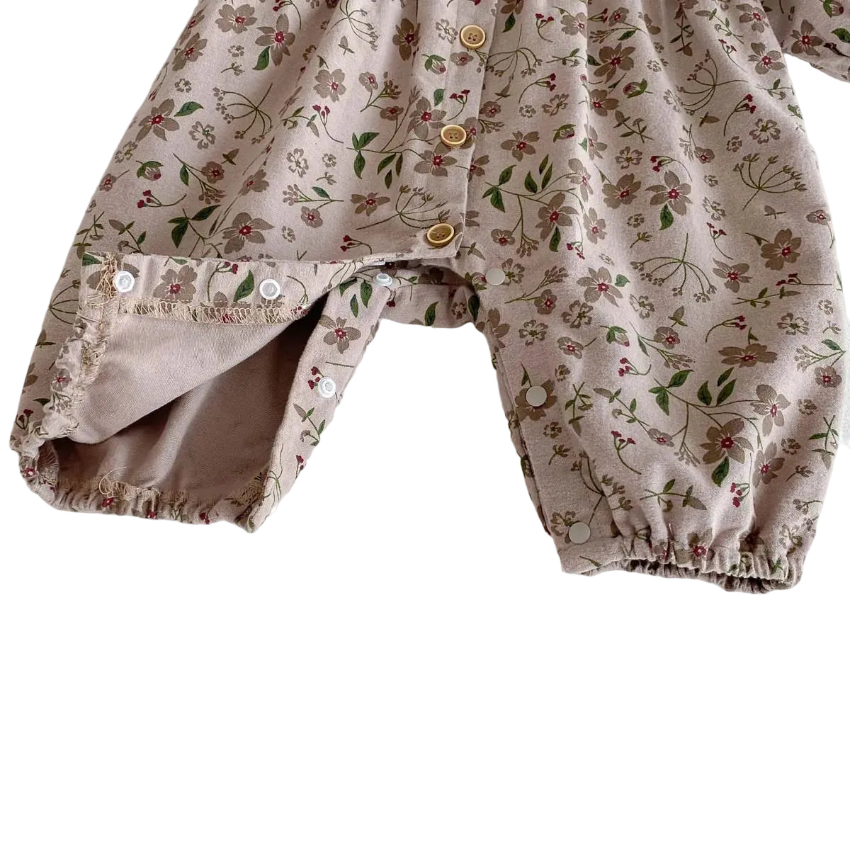 Close-up showing the bottom snap closures of the baby romper pulled open, designed for quick and easy diaper changes.
