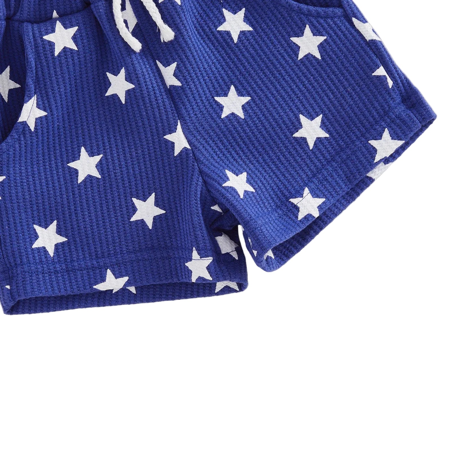 Close-up of the soft, ribbed fabric and bold white star pattern on the toddler boys blue summer shorts.