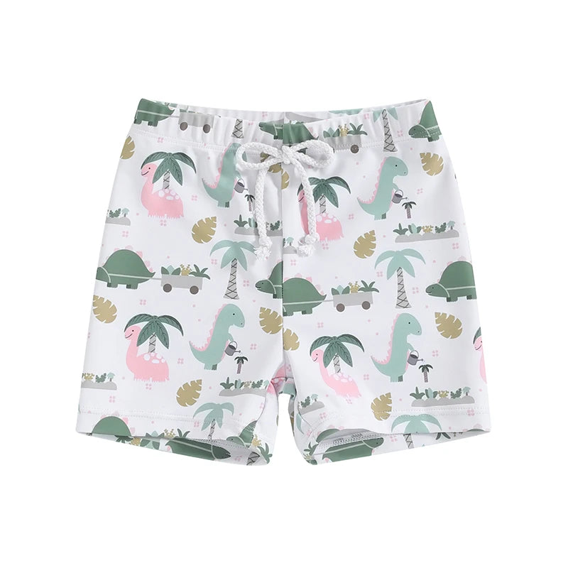 Little boys white swim trunks with a playful tropical dinosaur print featuring pink and green dinosaurs, palm trees, and gardening graphics.