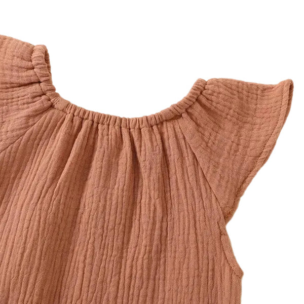 Close-up of the smooth back collar stitching and flutter sleeve layout on an earthy terracotta baby girl sunsuit.